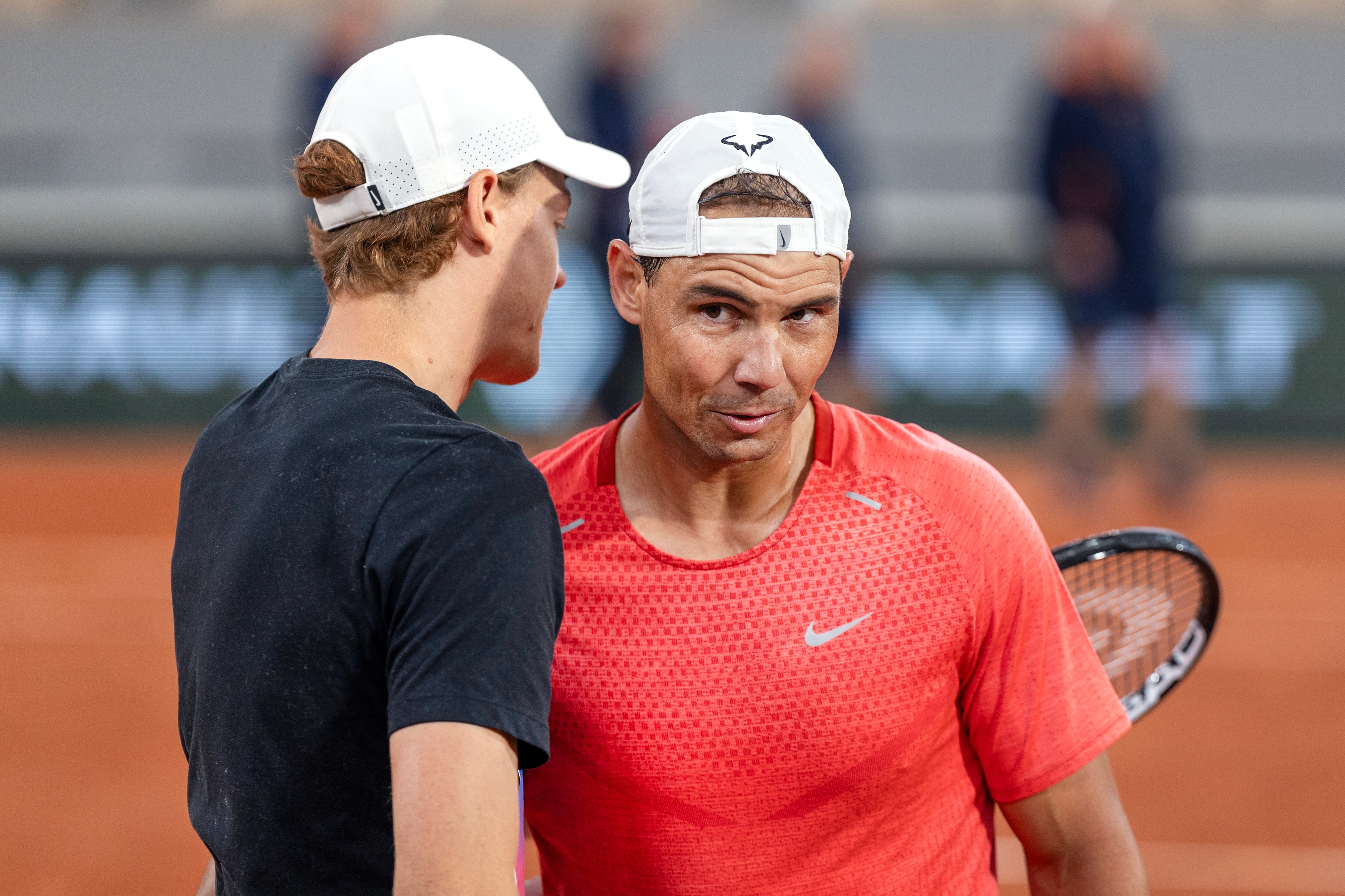 PARIS, FRANCE - MAY 22.   Rafael Nadal of Spain greets Jannik Sinner of Italy during training change over on Court Philippe-Chatrier as they practice in preparation for the 2024 French Open Tennis Tournament at Roland Garros on May 22nd, 2024, in Paris, France. (Photo by Tim Clayton/Corbis via Getty Images)
