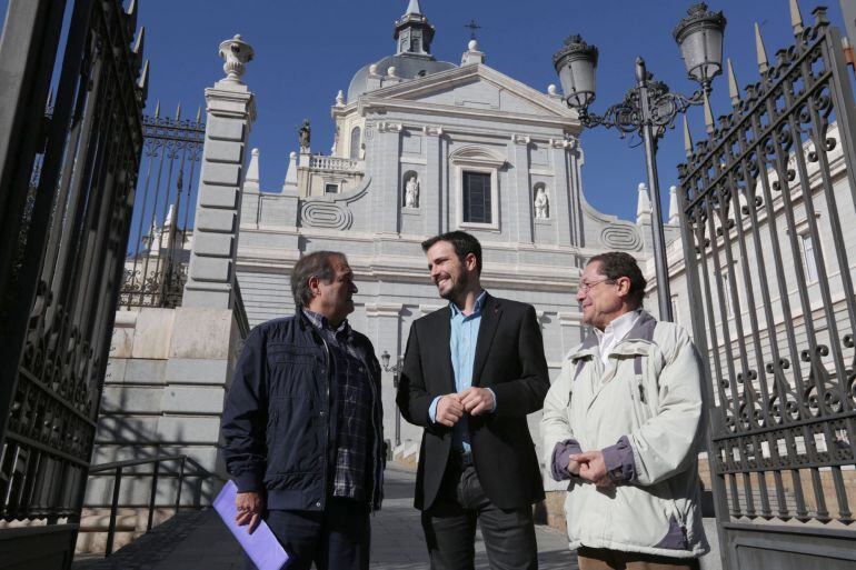 Fotografía facilitada por IU del candidato a la Presidencia del Gobierno de IU-Unidad Popular, Alberto Garzón (c), mientras conversa con el presidente de Europa Laica, Francisco Delgado (i), hoy en el exterior de la catedral de la Almudena de Madrid, tras