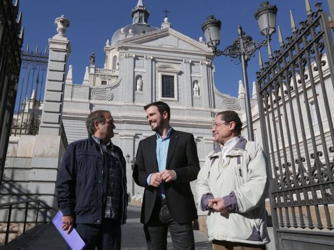 Fotografía facilitada por IU del candidato a la Presidencia del Gobierno de IU-Unidad Popular, Alberto Garzón (c), mientras conversa con el presidente de Europa Laica, Francisco Delgado (i), hoy en el exterior de la catedral de la Almudena de Madrid, tras