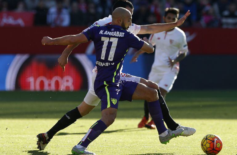 El francés Adil Ramí (detrás), del Sevilla, y el marroquí Amrabat, del Málaga, durante el partido correspondiente a la vigésima jornada de la Liga BBVA