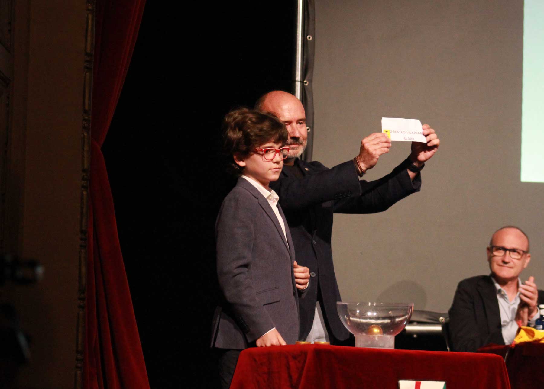 Instante en el que el secretario de la Asociación muestra el nombre de Mateo Vilaplana, con el Sant Jordiet 2025, Martín Bellver Sevila