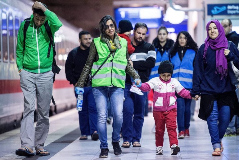 Una familia de refugiados camina en una plataforma de la estación de tren en el aeropuerto de Colonia (Alemania). Un tren de Salzburgo, Austria, con más de 550 personas ha llegado este martes a la estación de trenes del aeropuerto de Colonia