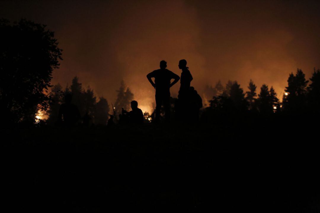 Evia Island (Greece), 09 08 2021.- Local youths and volunteers gather in an open field and wait to support during a wildfire near the village of Kamatriades in the island of Evia, Greece, 09 August 2021. Fires that broke out in Attica and Evia island this