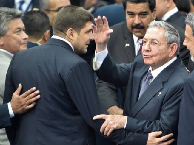 Cuba's President Raul Castro (R) waves to journalists as Venezuela's President Nicolas Maduro looks on after the family picture of the VII Americas Summit in Panama City on April 11, 2015. AFP PHOTO / Rodrigo ARANGUA