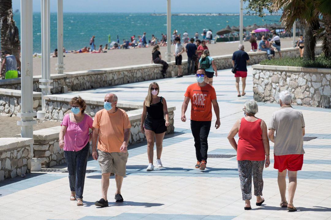 Varias personas pasean por el paseo marítimo Antonio Banderas