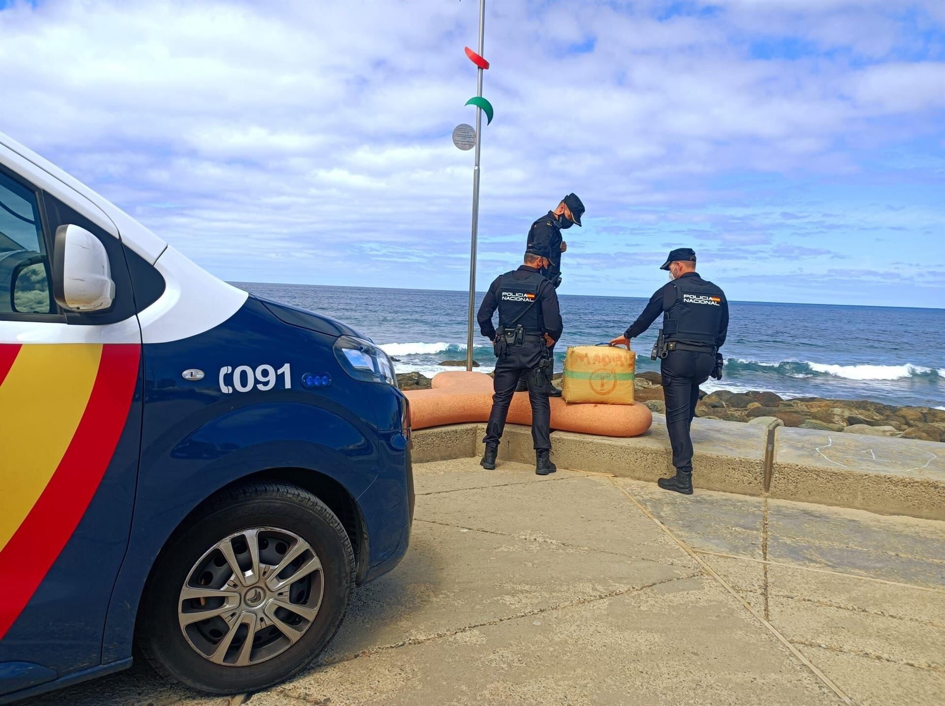 Agentes de la Policía Nacional junto el segundo fardo de droga que ha llegado a la playa de Las Canteras, en Las Palmas de Gran Canaria