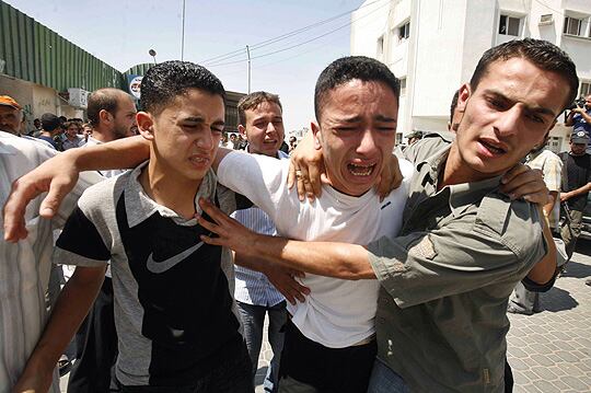 MÁS MUERTES. Un grupo de palestinos reacciona tras la muerte de cuatro personas en Gaza por un ataque israelí.