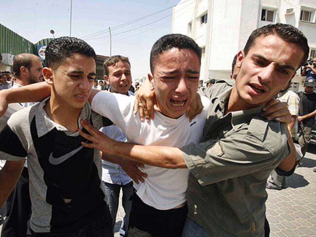 MÁS MUERTES. Un grupo de palestinos reacciona tras la muerte de cuatro personas en Gaza por un ataque israelí.