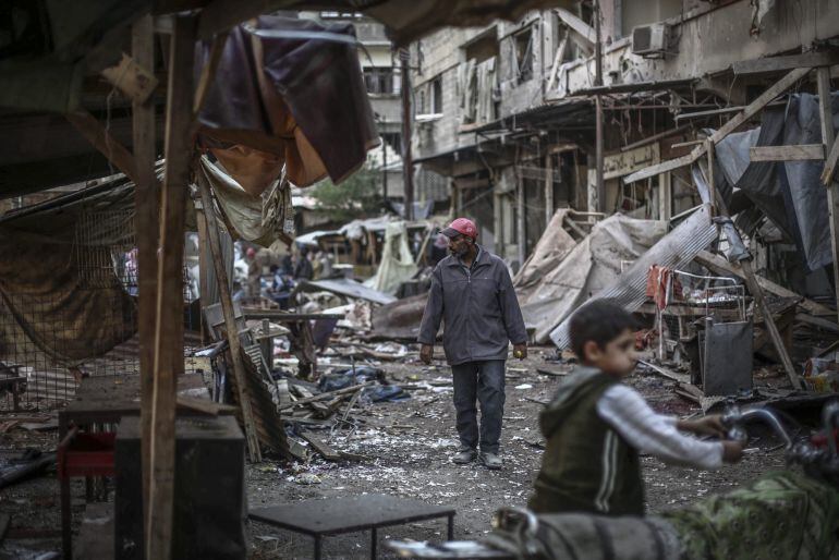 Un ciudadano revisa los destrozos registrados en un mercado tras un ataque de las fuerzas del régimen sirio en Duma, a las afueras de Damasco (Siria)