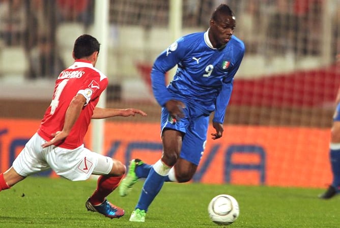 Mario Balotelli disputa el balón con Gareth Sciberras, de Malta, durante su partido clasificatorio para la copa del mundo de Brasil 2014.