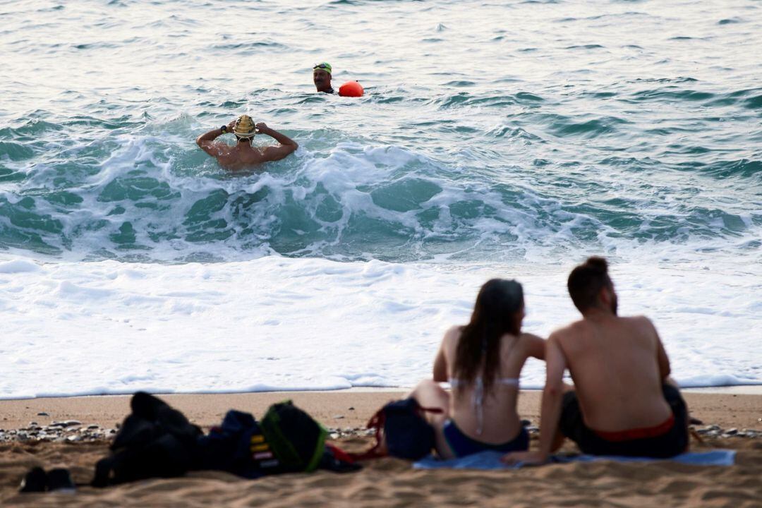Dos nadadores entran en el agua en la playa