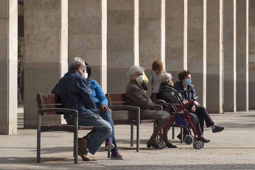 Varios ancianos sentados en un banco de la Gran Vía de Logroño.