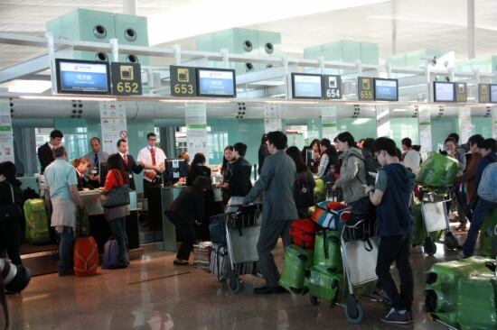 Turistes catalans esperant en un mostrador d&#039;embarcament.