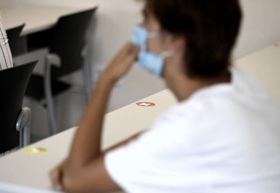 Un alumno con mascarilla en clase.