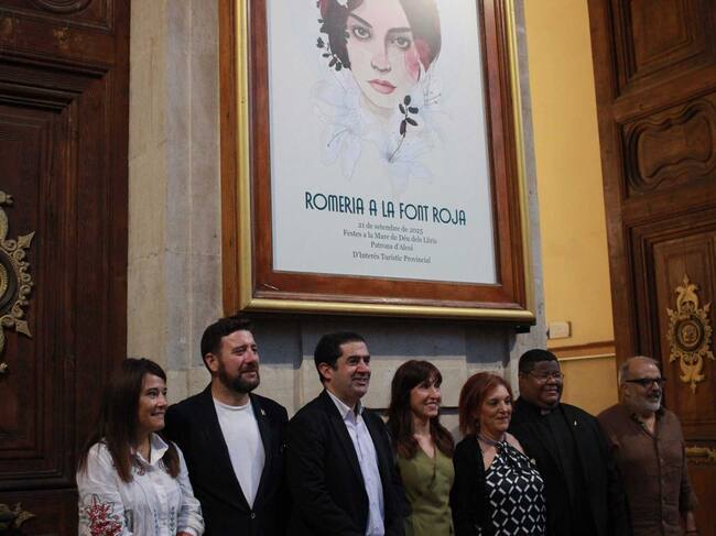 La autora, Lola Llopis, fotografiándose bajo su obra, con las autoridades presentes en el acto del descubrimiento del cartel
