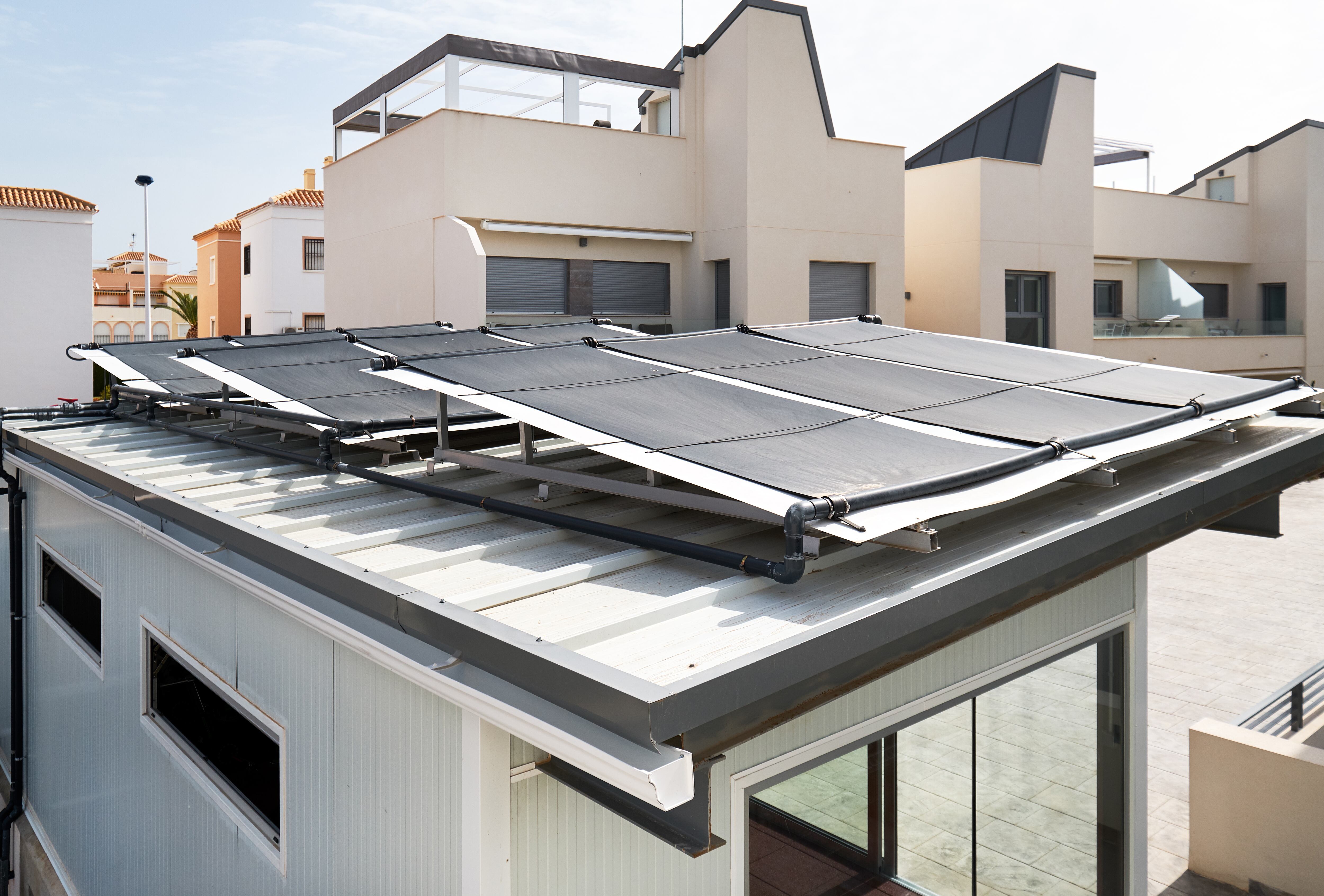 Paneles solares destinados a calentar una piscina en un edificio de Alicante.