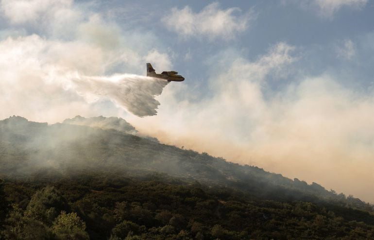 Un avión realiza labores de extincións de un incendio forestal