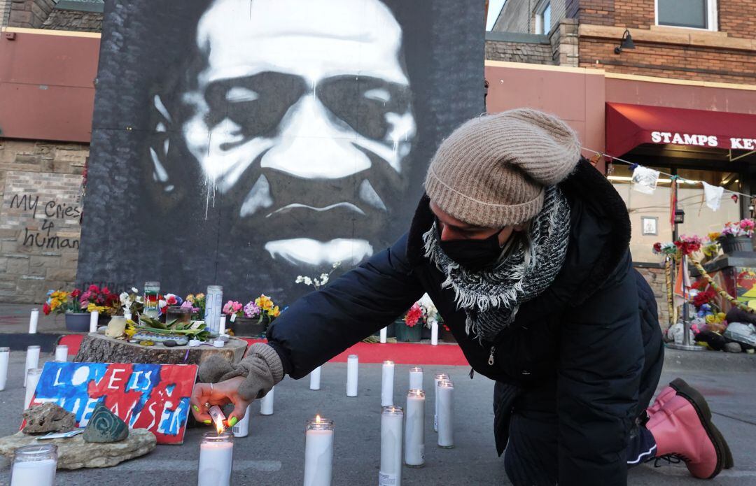 Activistas comunitarios encienden velas en un monumento cerca del sitio donde murió George Floyd.