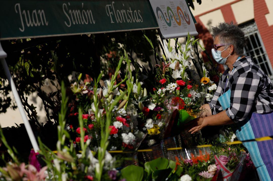 Una empleada coloca flores en su floristería