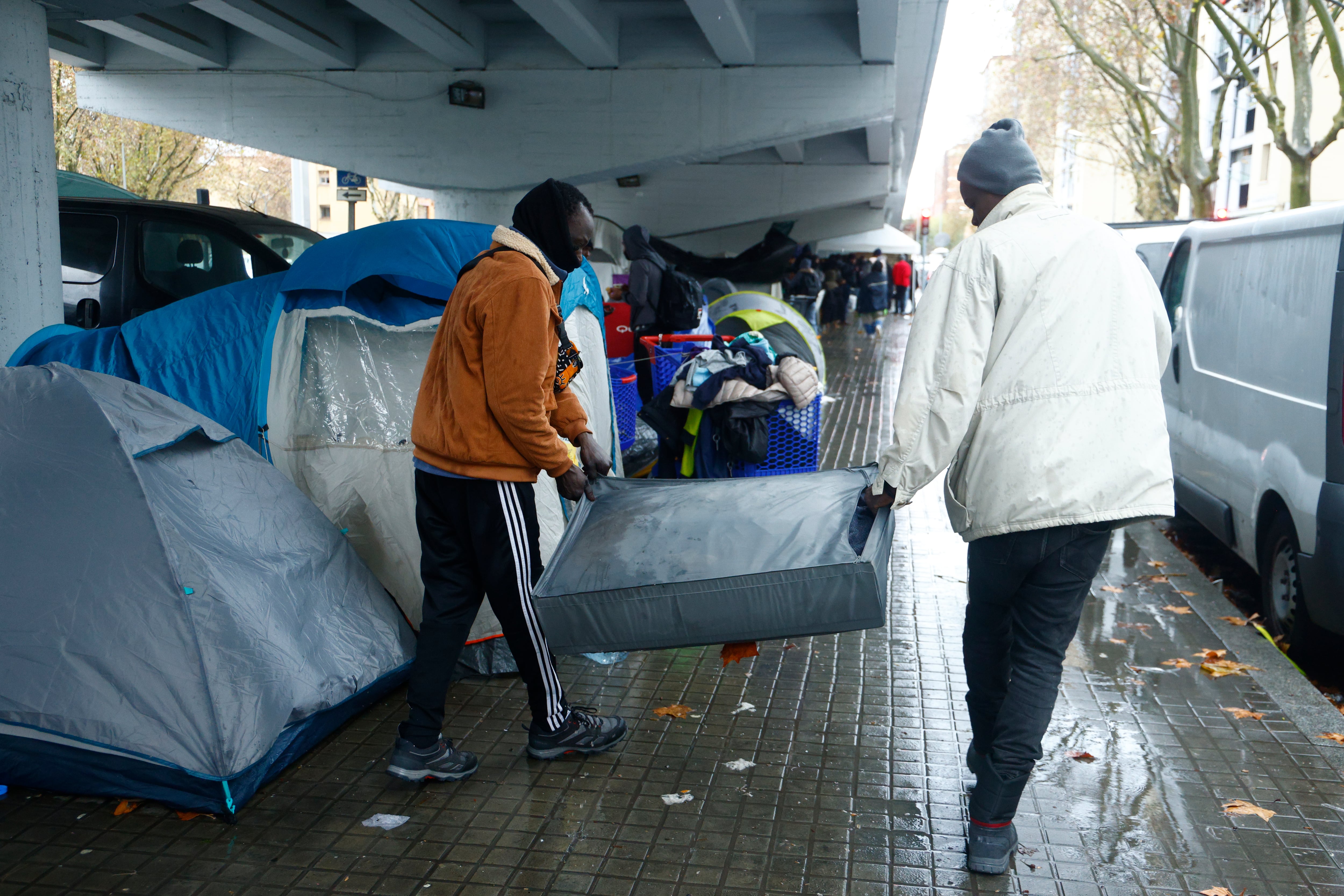 Decenas de personas desalojadas del antiguo instituto B9 de Badalona (Barcelona) siguen acampadas bajo un puente de la carretera C-31, mientras entidades sociales reclaman a las administraciones públicas una solución.
