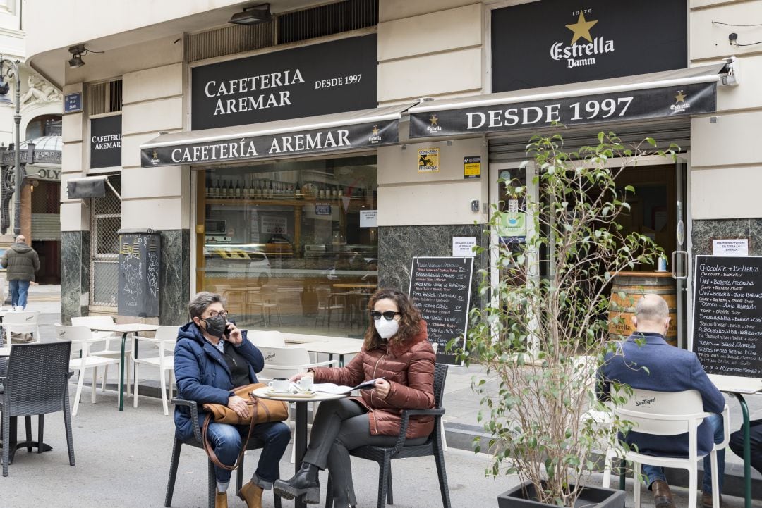 Varias personas sentadas en la terraza de un bar en València. 