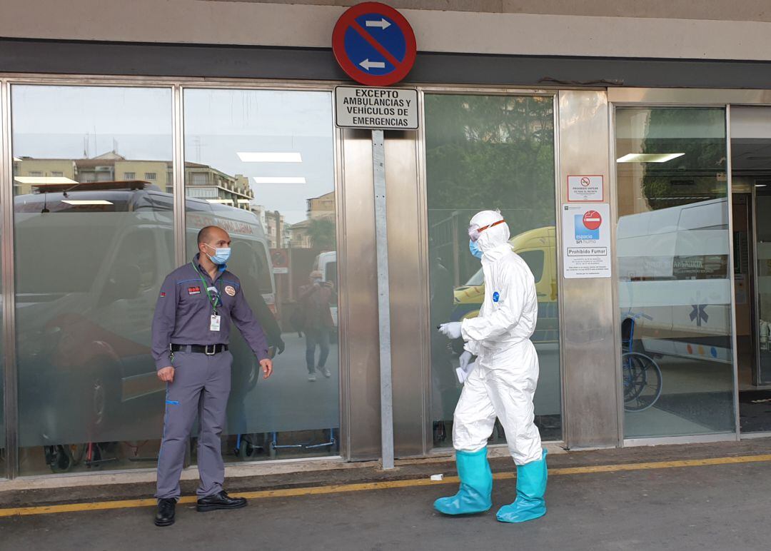 Imagen de archivo de un conductor de ambulancia, protegido frente a la covid-19, se dirige a un vigilante de seguridad en las puertas del servicio de Urgencias del hospital Virgen de las Nieves de Granada