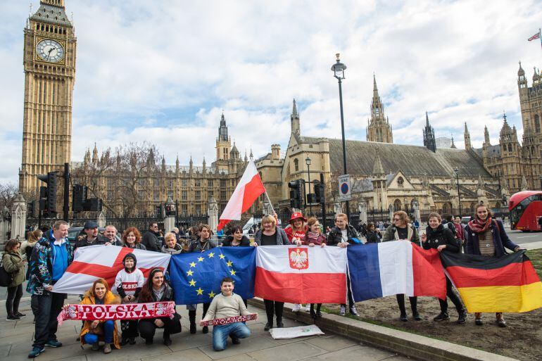 Trabajadores inmigrantes protestan con banderas ante el Parlamento británico.