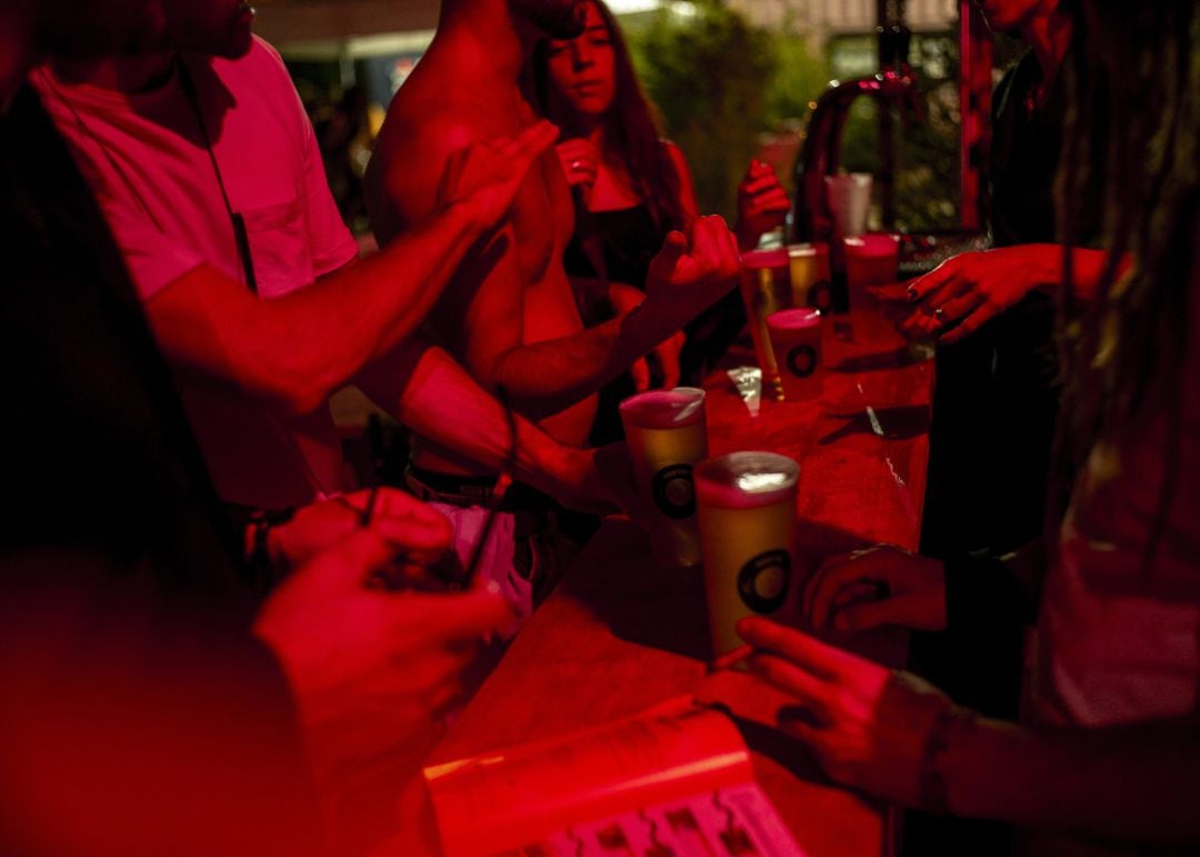 Varias personas piden bebida en una barra de bar