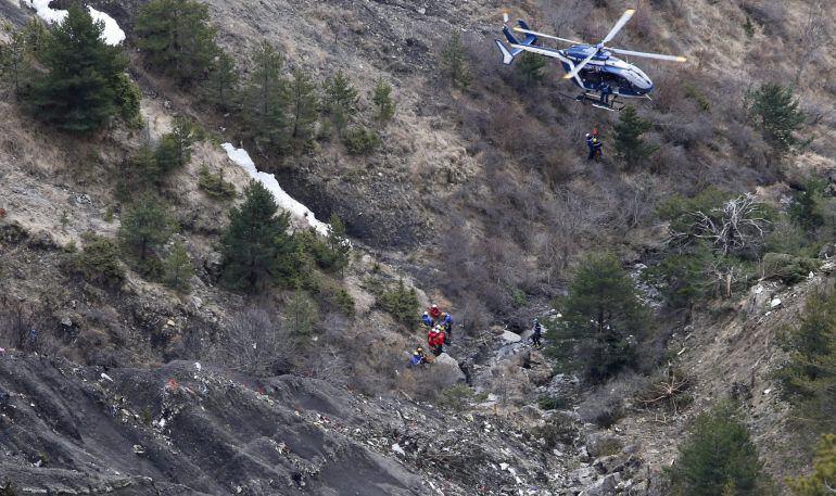 Unos miembros de los servicios de rescate llegan en helicóptero al área de alta montaña donde se estrelló un avión en los Alpes franceses, cerca de la localidad de Seyne-les-Alpes