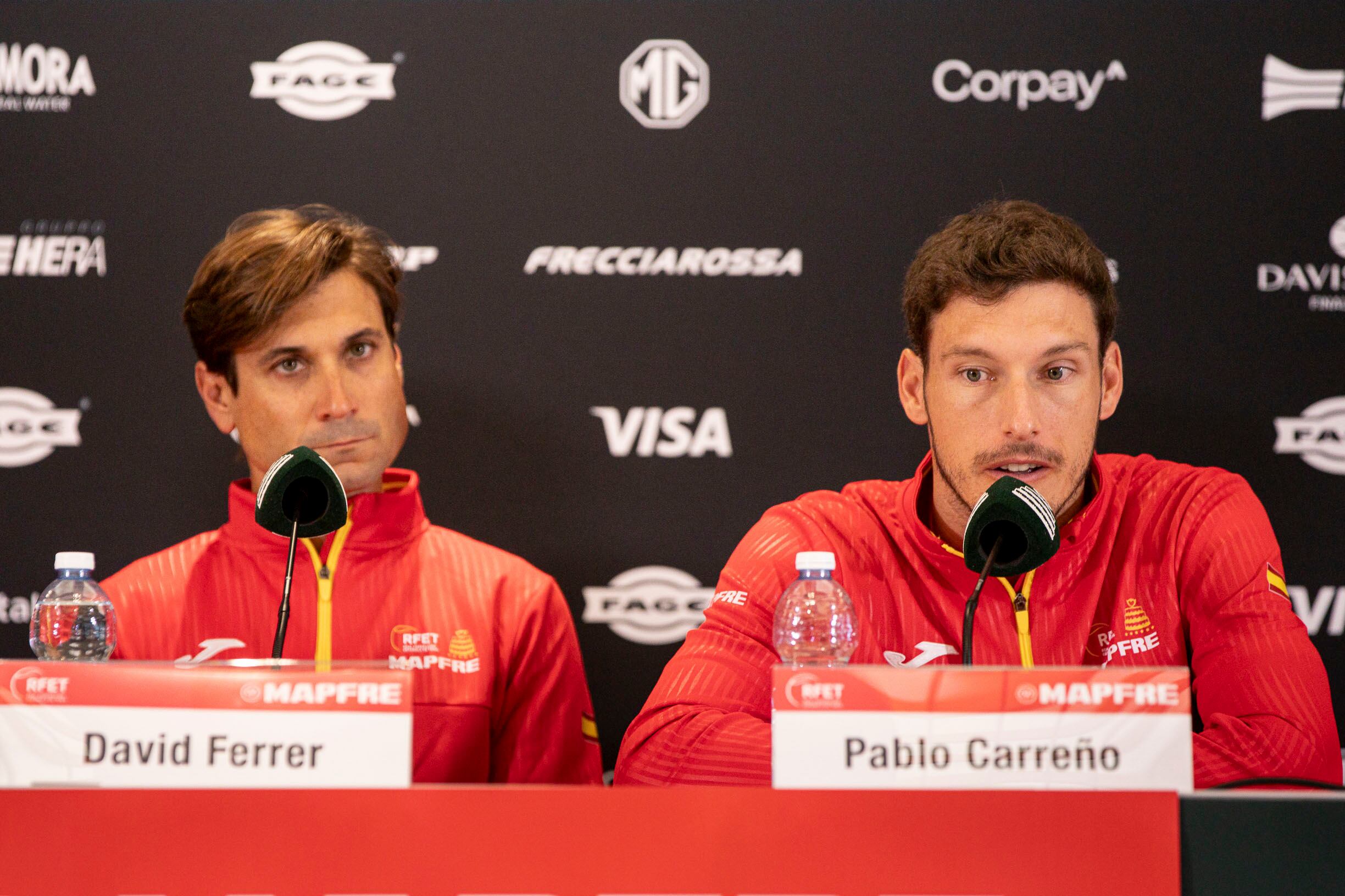 BOLONIA (ITALIA), 18/11/2025.- El tenista español Pablo Carreño (d) junto a David Ferrer, capitán del equipo español de la Copa Davis, durante una rueda de prensa este martes en Bolonia. Ferrer reconoció este martes que la baja de Carlos Alcaraz, número 1 del mundo, hace que su equipo, que incluye al valenciano Pedro Martínez, se resienta, pero indicó que mantiene la confianza en los suyos para "hacer algo bueno". EFE/RFET SOLO USO EDITORIAL/SOLO DISPONIBLE PARA ILUSTRAR LA NOTICIA QUE ACOMPAÑA (CRÉDITO OBLIGATORIO)