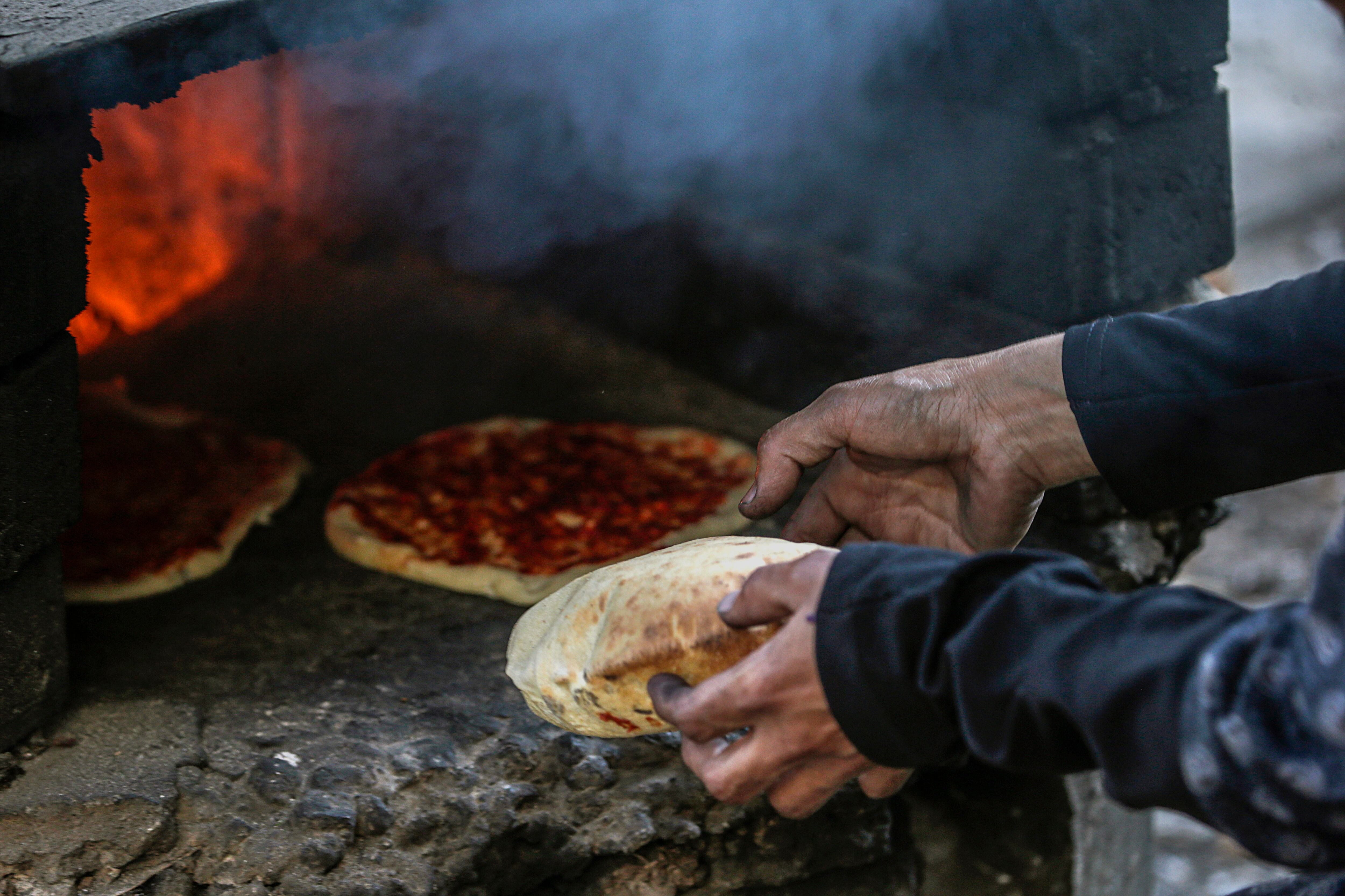 Una desplazada palestina prepara comida en el campo de refugiados instalados en el estadio Al Yarmouk de la ciudad de Gaza