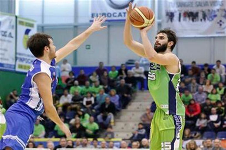 Carles Marzo lanza a canasta con la camiseta del CD Obila