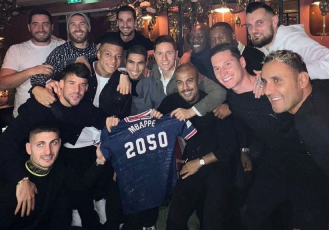 Los jugadores del PSG posan con la camista que le han regalado a Mbappé