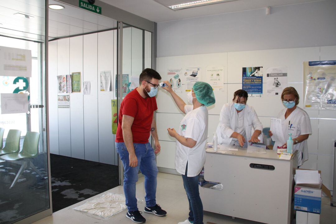 Profesional sanitario toma temperatura  a un paciente. 
 