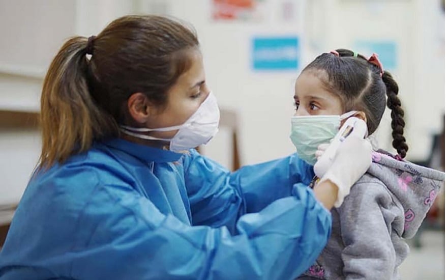 Colocando mascarilla a una niña