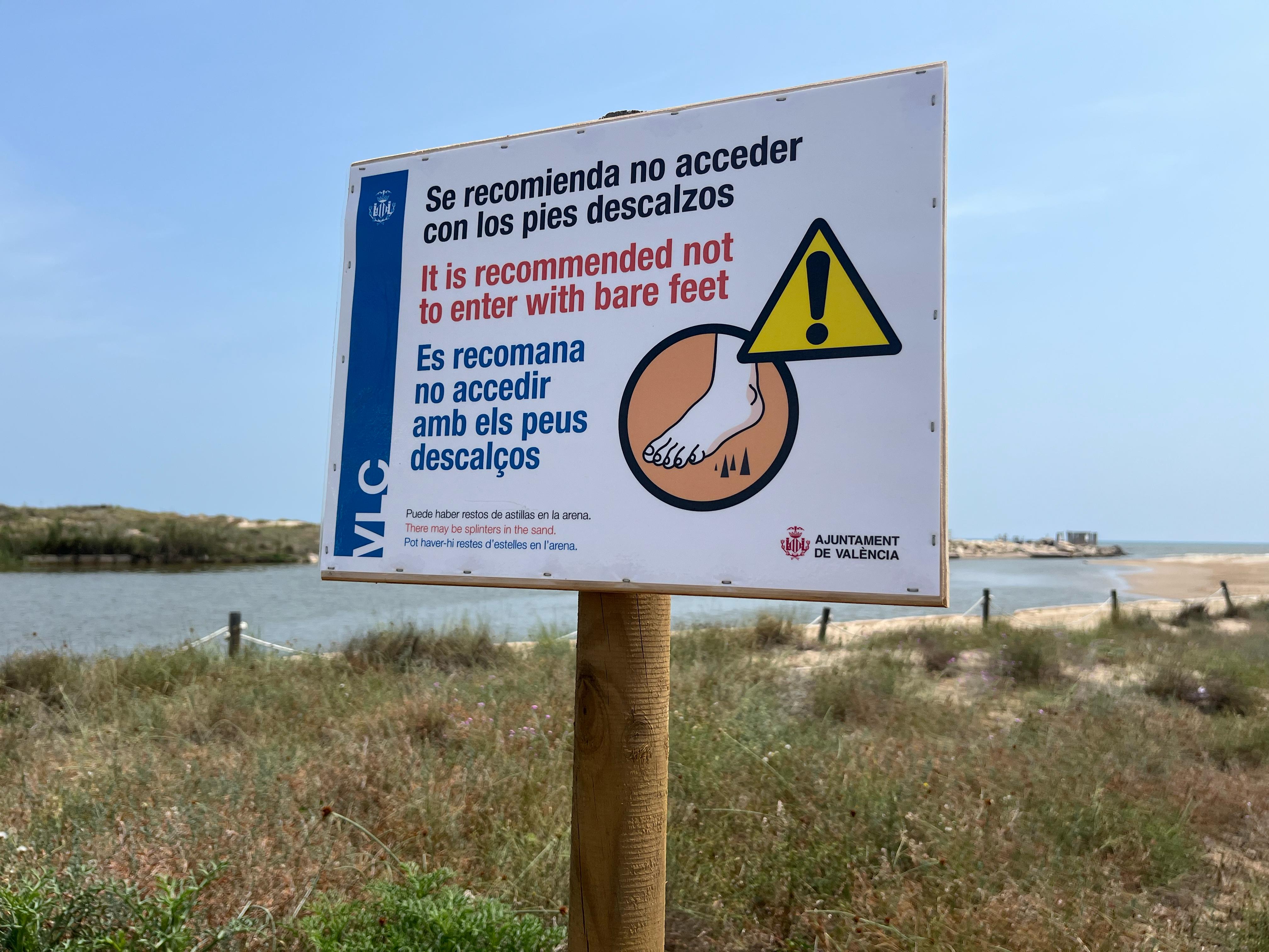 Cartel del Ayuntamiento de València en el que se pide no entrar sin zapatos a las playas afectadas por la DANA.