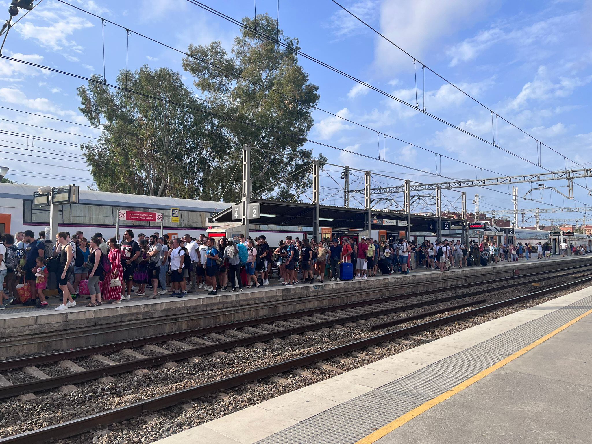 Usuaris de Rodalies esperant l'arribada d'un tren a l'estació de Vilanova