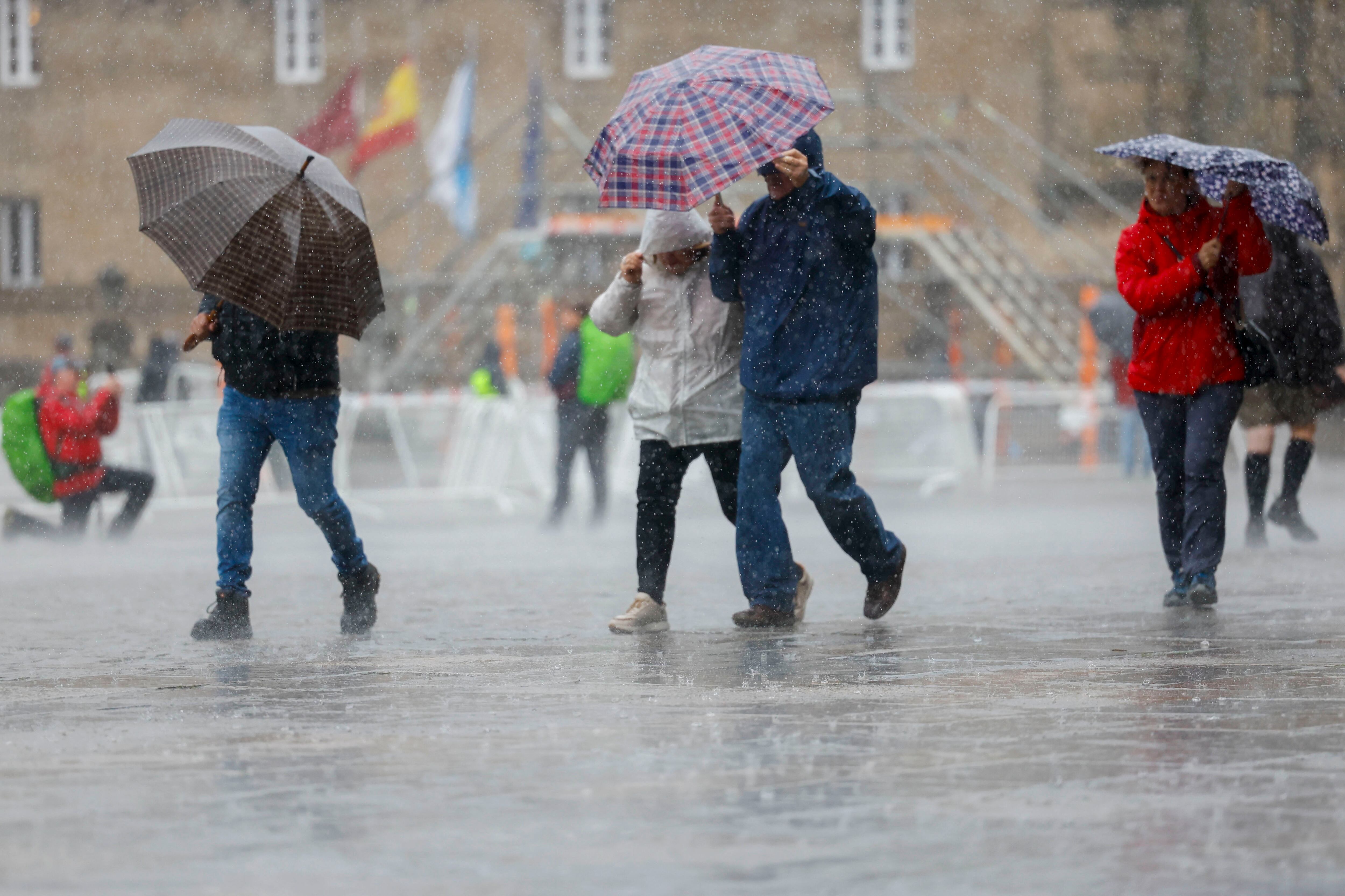 Turistas bajo la lluvia este sábado en la plaza del Obradoiro en Santiago de Compostela