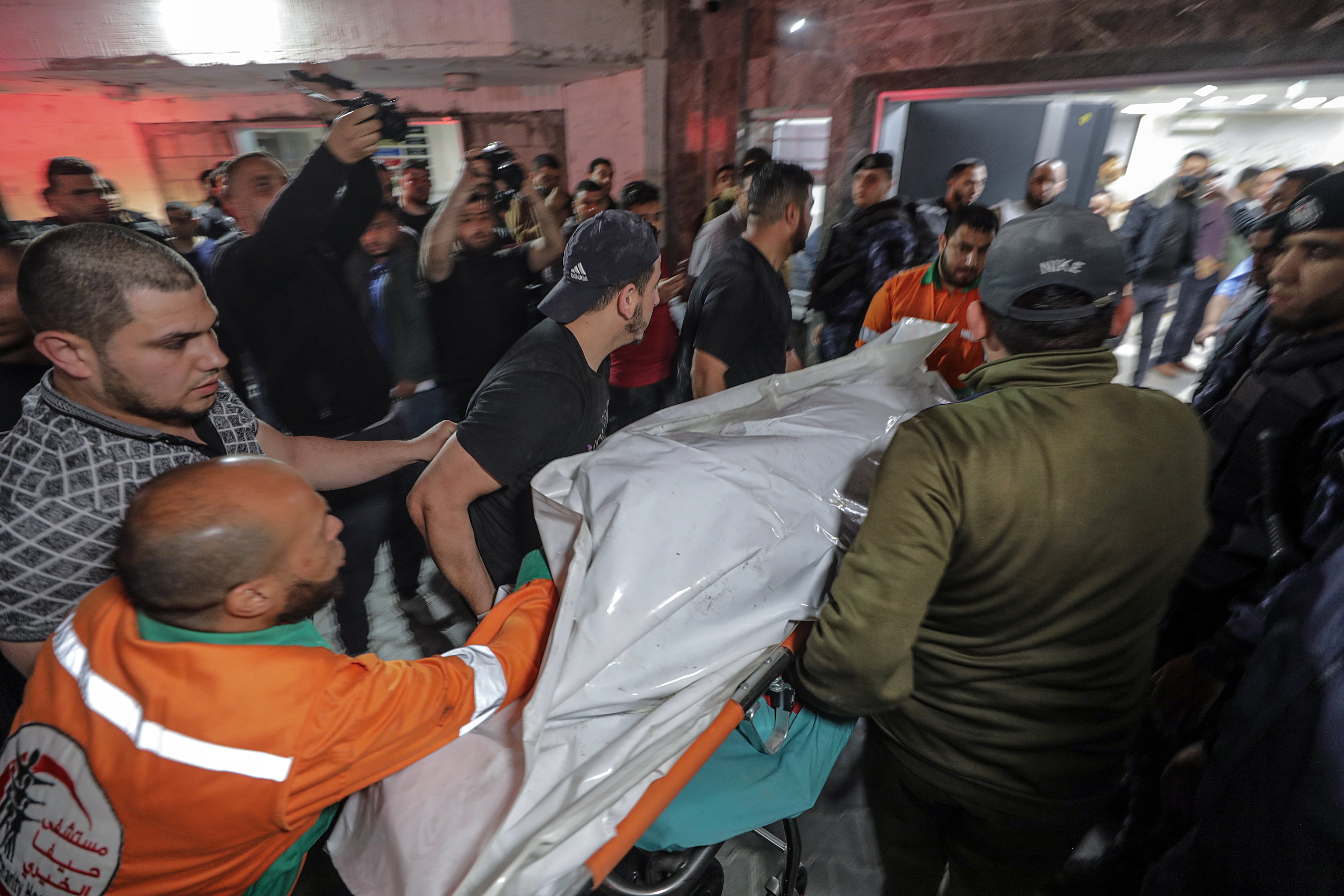 Palestinos trasladan el cuerpo de un miembro del movimiento Yihad Islámica en el hospital Al Shifa tras los ataques aéreos israelíes en la ciudad de Gaza