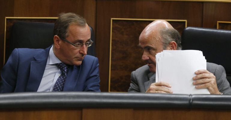 GRA091. MADRID, 18/08/2015.- El ministro de Economía, Luis de Guindos (d), conversa con el ministro de Sanidad, Alfonso Alonso (i), durante el pleno del Congreso que hoy debate el tercer programa de ayudas a Grecia y la contribución española, cifrada en 1