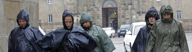 Los turistas pasean bajo la lluvia en la plaza del Obradoiro, en Santiago de Compostela