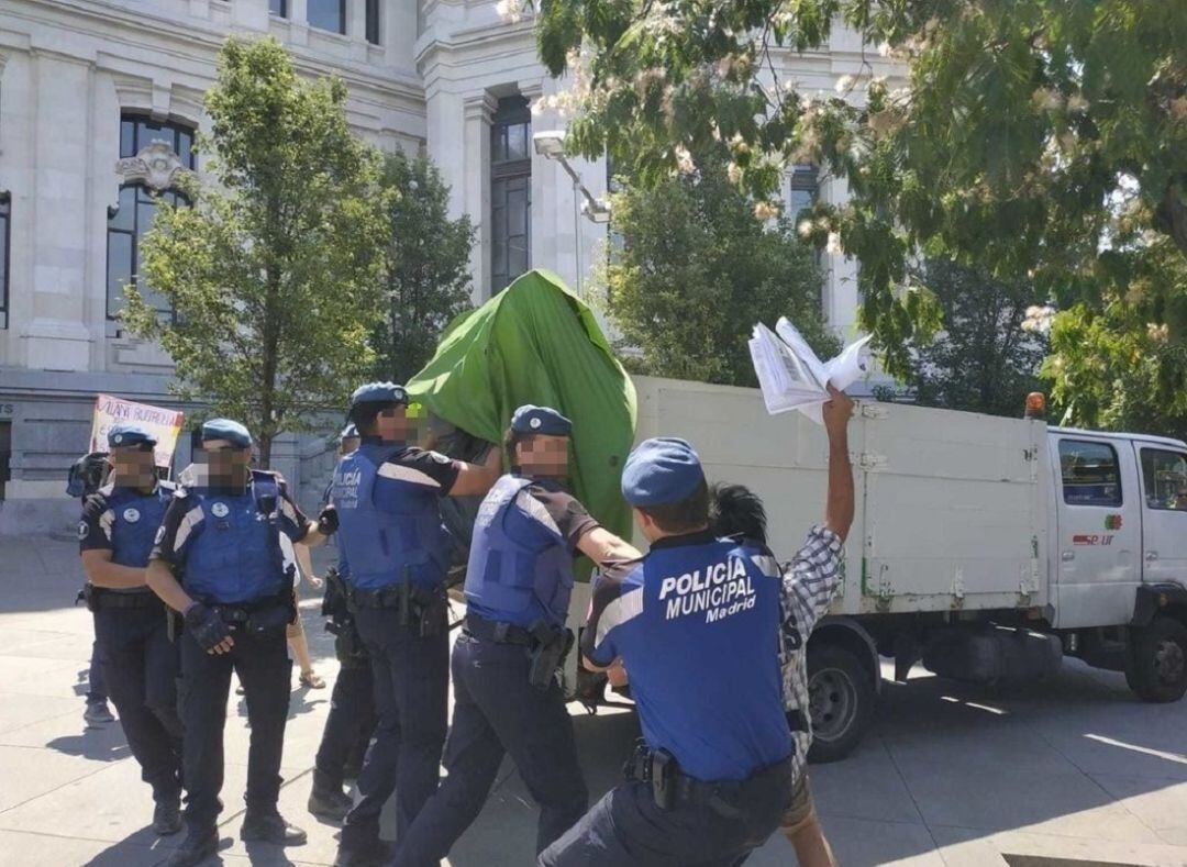 Varios agentes de la Policía municipal desalojan a los acampados frente al Ayuntamiento. 