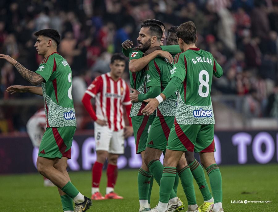 El Granada celebra su victoria en El Molinón ante la mirada resignada del jugador del Sporting Nacho Martín.