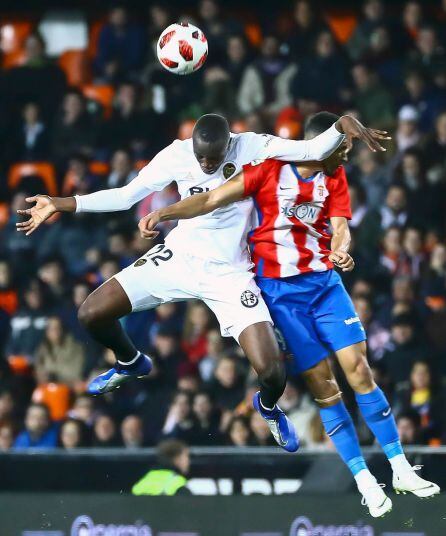 El jugador del Valencia, Mouctar Diakhaby (i) y Nicholas Alexander Blackman , del Sporting de Gijón, durante el partido de vuelta de octavos de final de la Copa del Rey jugado en el estadio de Mestalla.