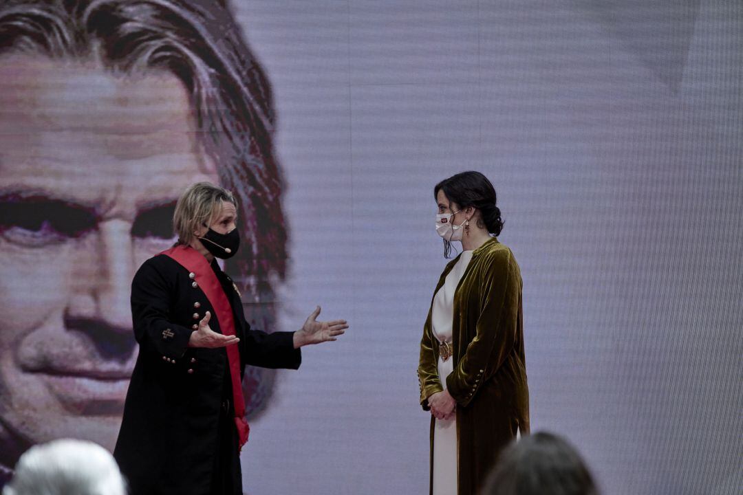 La presidenta de la Comunidad de Madrid, Isabel Díaz Ayuso (d), entrega la Gran Cruz de la Orden del Dos de Mayo al músico Nacho Cano.