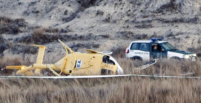 Un vehículo de la Guardia Civil junto al helicóptero que se estrelló el pasado mes de marzo en las inmediaciones de la localidad turolense de Villel, en el que murieron seis trabajadores del servicio de extinción de incendios del Gobierno de Aragón