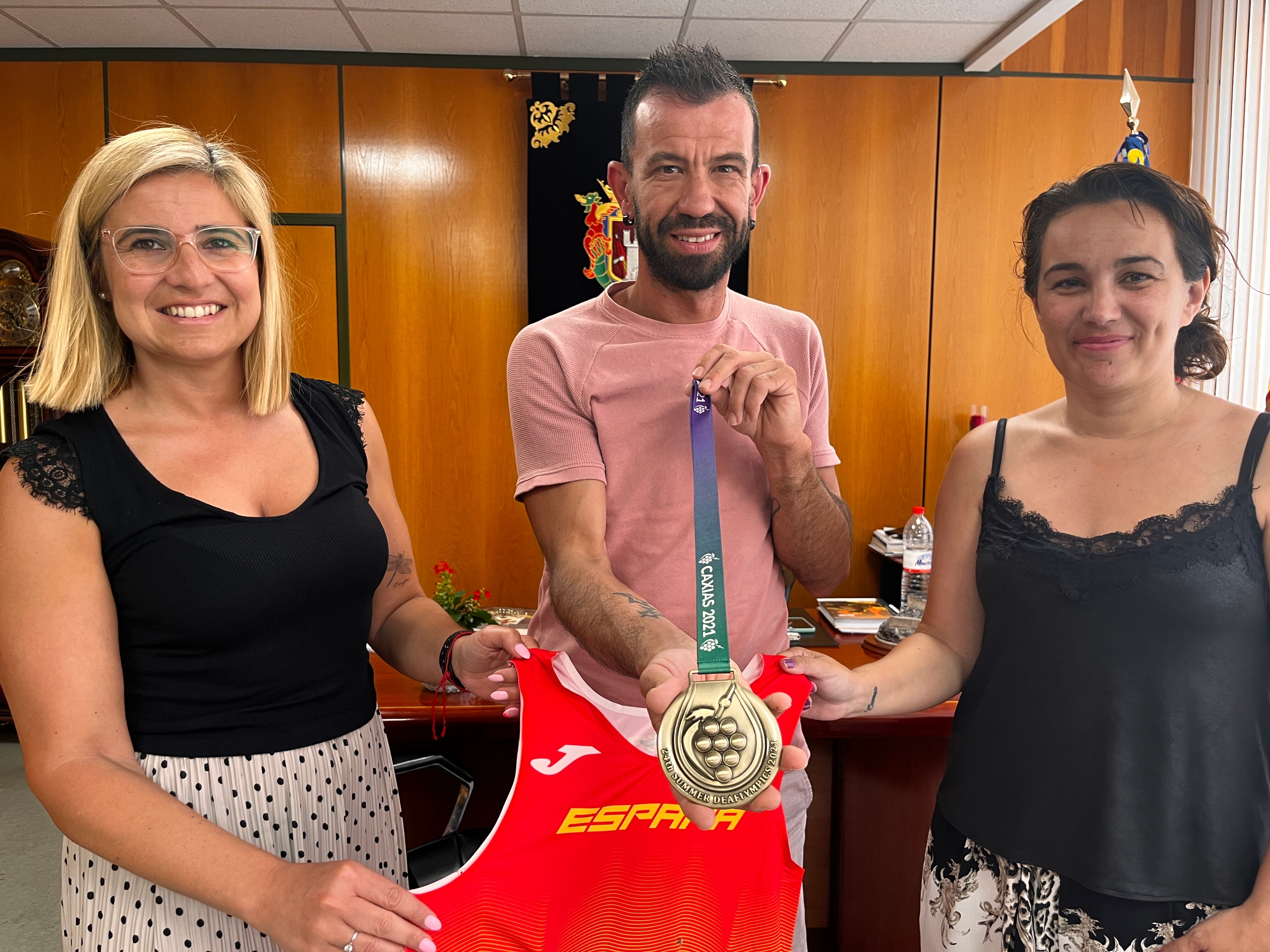 El atleta petrerí Juanma González entre la alcaldesa de Petrer, Irene Navarro y la edil de Deportes, Patricia Martínez (D)