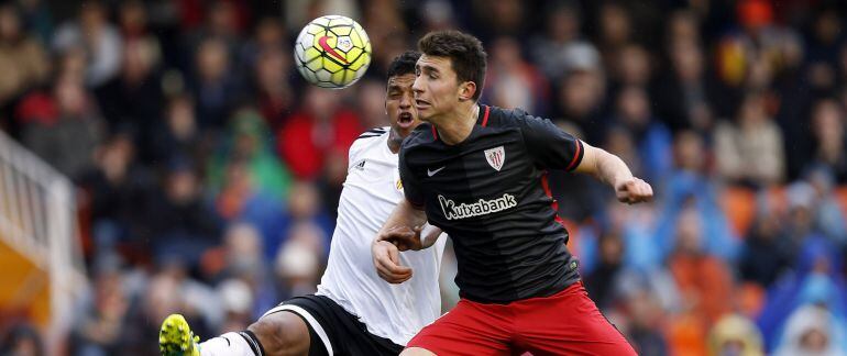 El defensa del Valencia Aderlan Santos (i) disputa el balón con el defensa del Athletic Club Aymeric Laporte durante el partido de liga que disputan esta tarde en el estadio de Mestalla