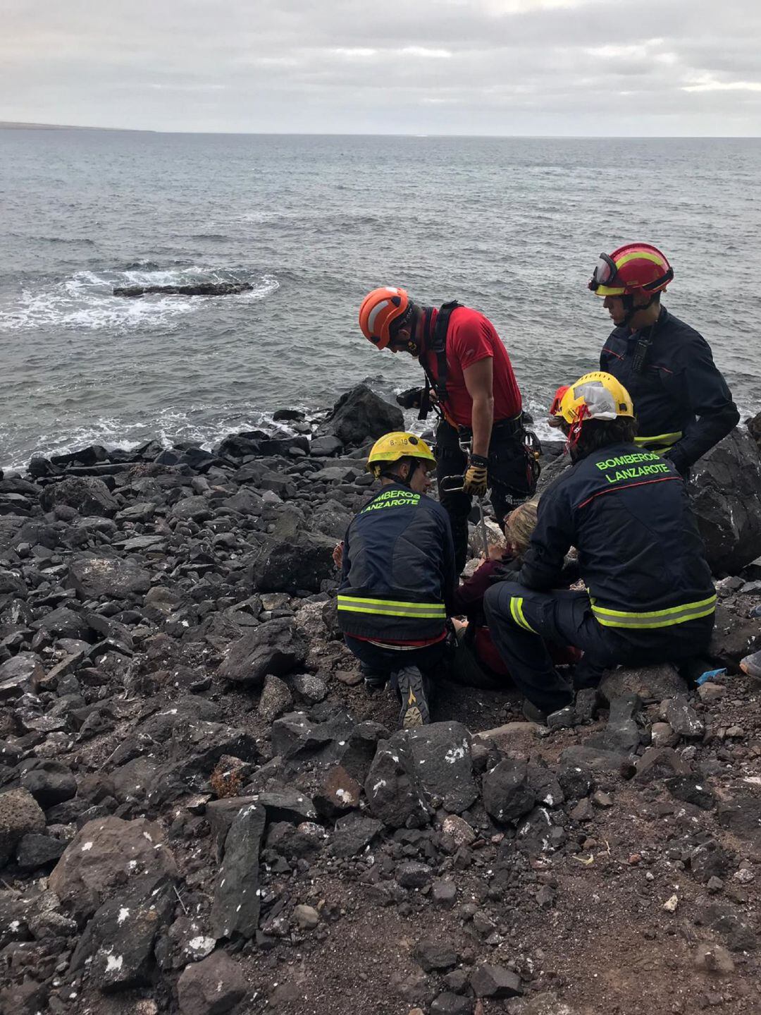 Los bomberos atendiendo a la senderista herida.