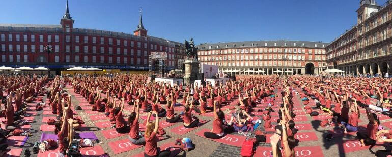 Más de 3.000 hombres y mujeres participan en una clase magistral de yoga en la Plaza Mayor de Madrid.